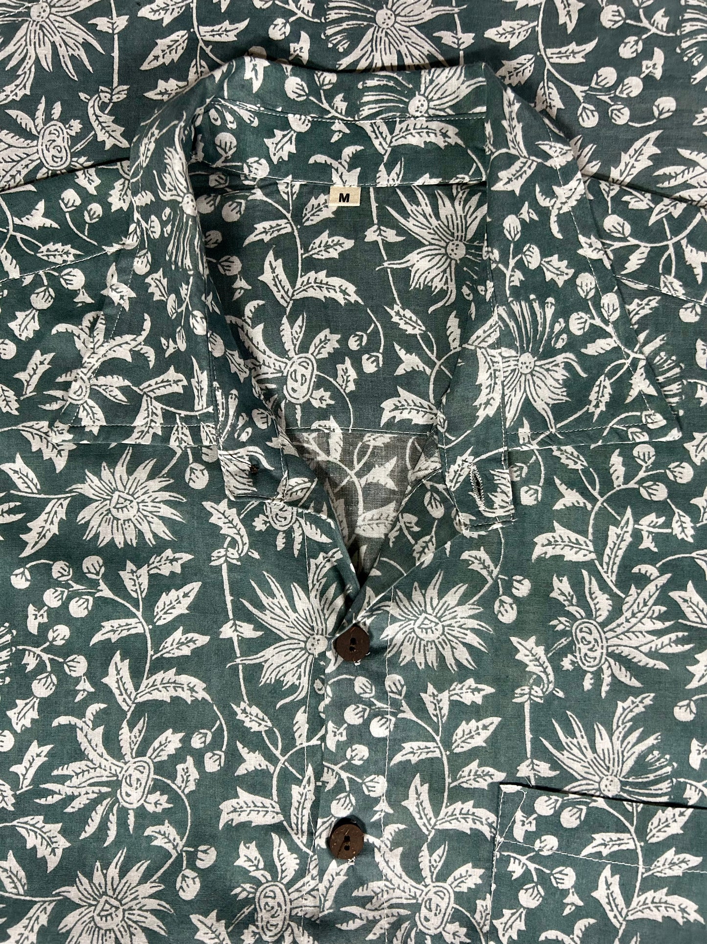 Close-up of a shirt with a floral pattern on a dark green background