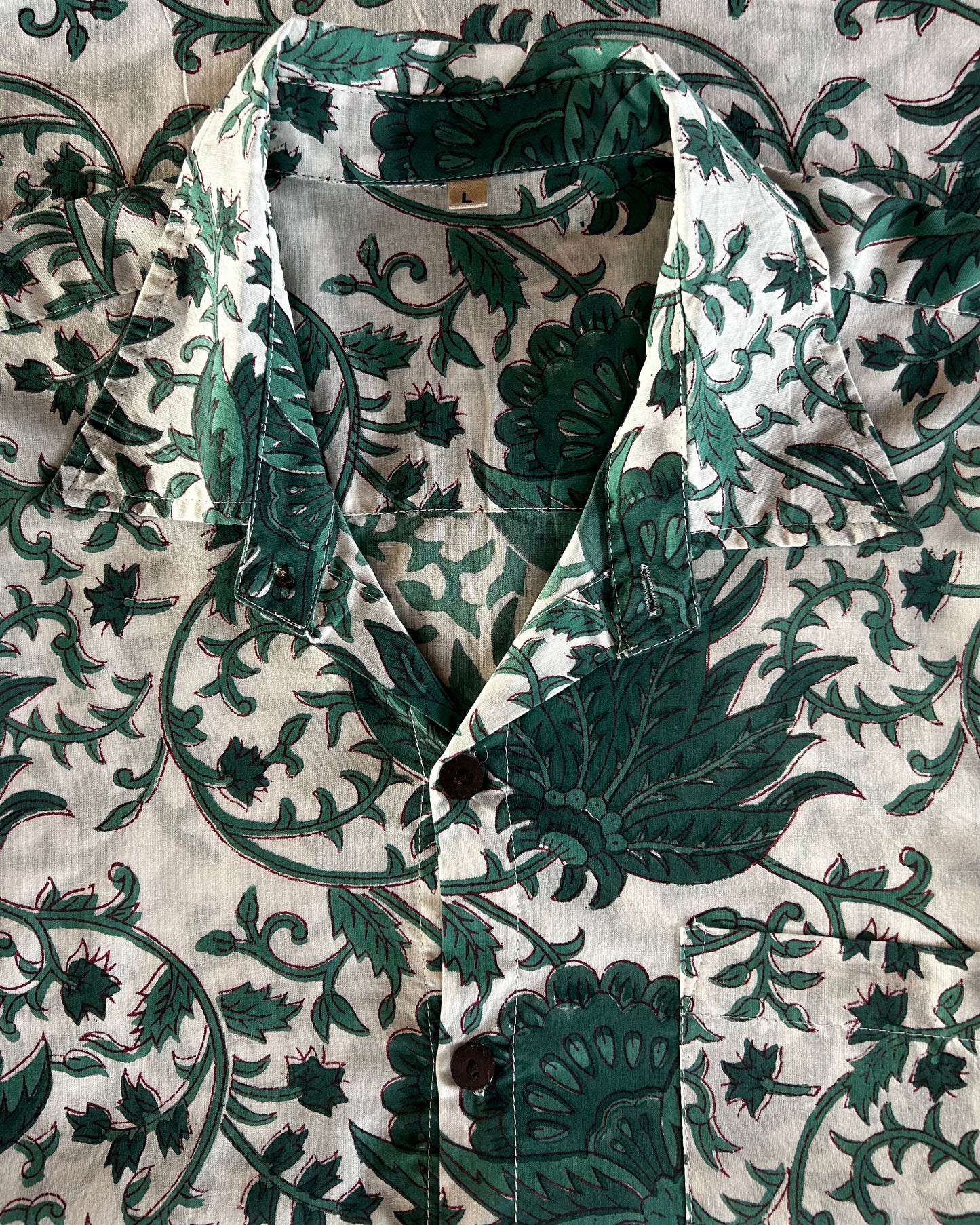 Green and white floral patterned fabric on a textured background