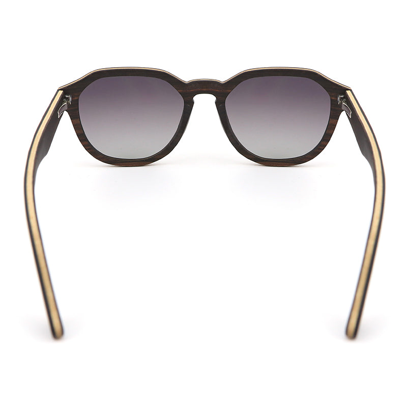 Our Hashtag Bamboo Auroras feature a round eyeglasses with a solid wood frame in ebony and maple laminate, featuring carved wood arms and spring hinges. The lenses are gradient grey polarised.