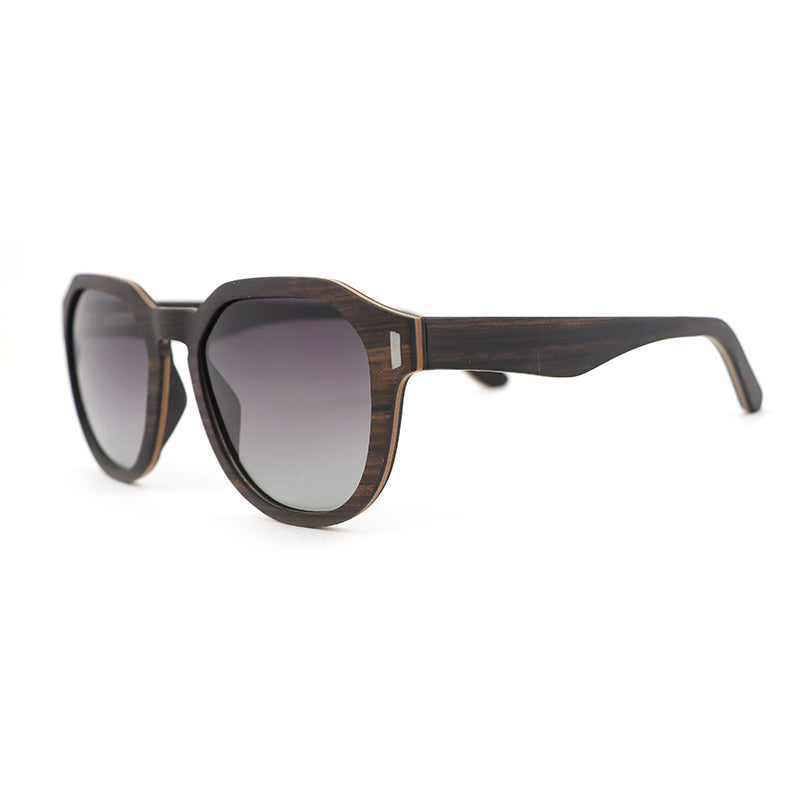 Our Hashtag Bamboo Auroras feature a round eyeglasses with a solid wood frame in ebony and maple laminate, featuring carved wood arms and spring hinges. The lenses are gradient grey polarised.
