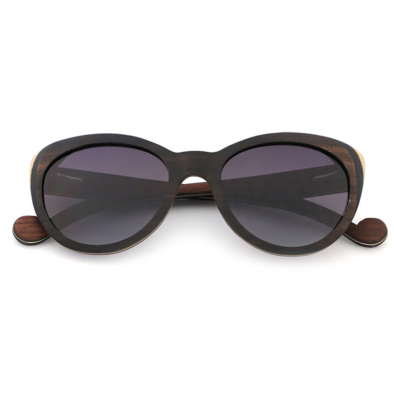 Introducing our newest ladies' sunglasses, The Solange, made from beautiful ebony wood with eye-catching laminate layers visible on the edges.  Handcarved arms with grey polarized lenses to elevate your look.