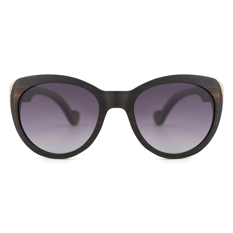 Introducing our newest ladies' sunglasses, The Solange, made from beautiful ebony wood with eye-catching laminate layers visible on the edges.  Handcarved arms with grey polarized lenses to elevate your look.