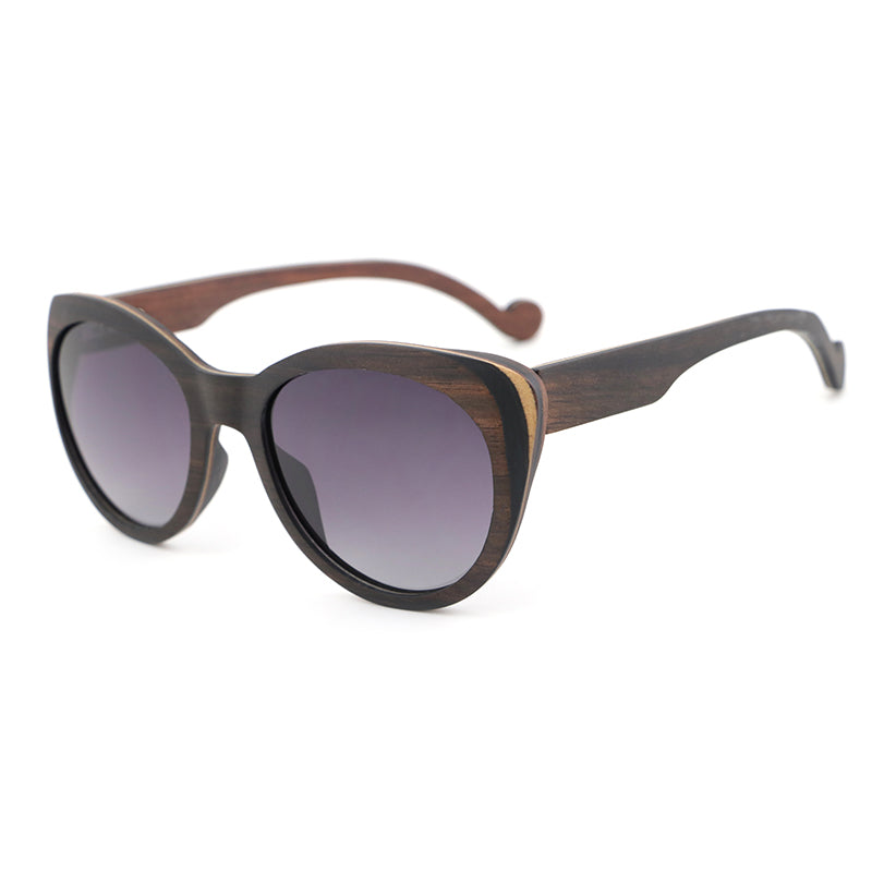 Introducing our newest ladies' sunglasses, The Solange, made from beautiful ebony wood with eye-catching laminate layers visible on the edges.  Handcarved arms with grey polarized lenses to elevate your look.