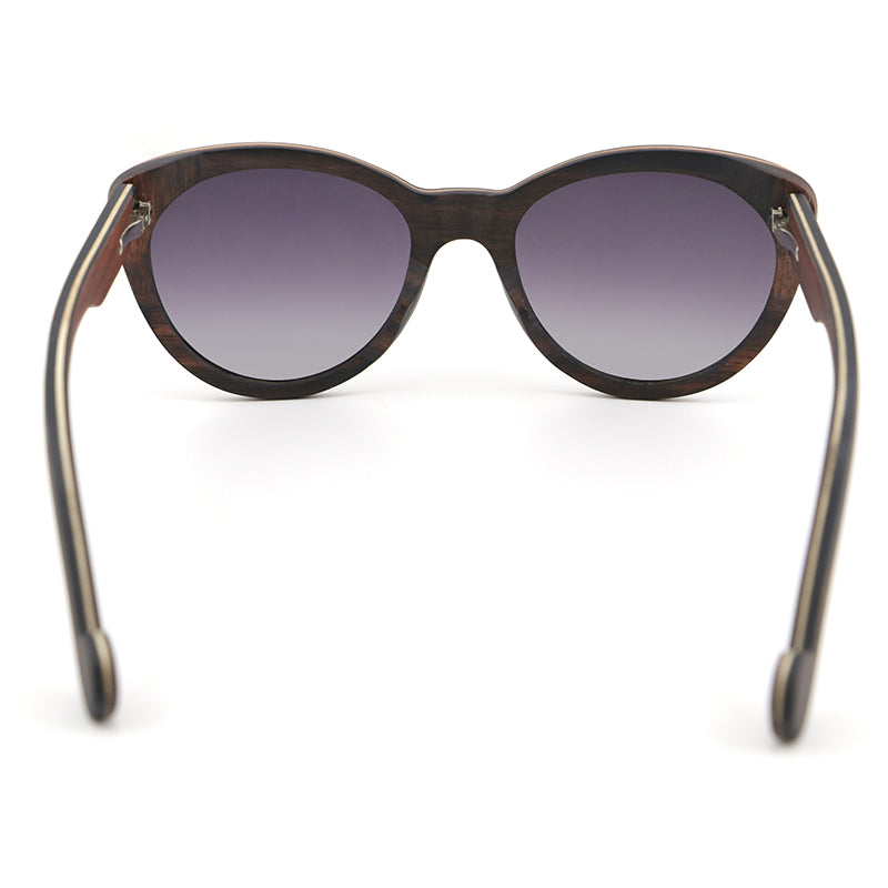 Introducing our newest ladies' sunglasses, The Solange, made from beautiful ebony wood with eye-catching laminate layers visible on the edges.  Handcarved arms with grey polarized lenses to elevate your look.