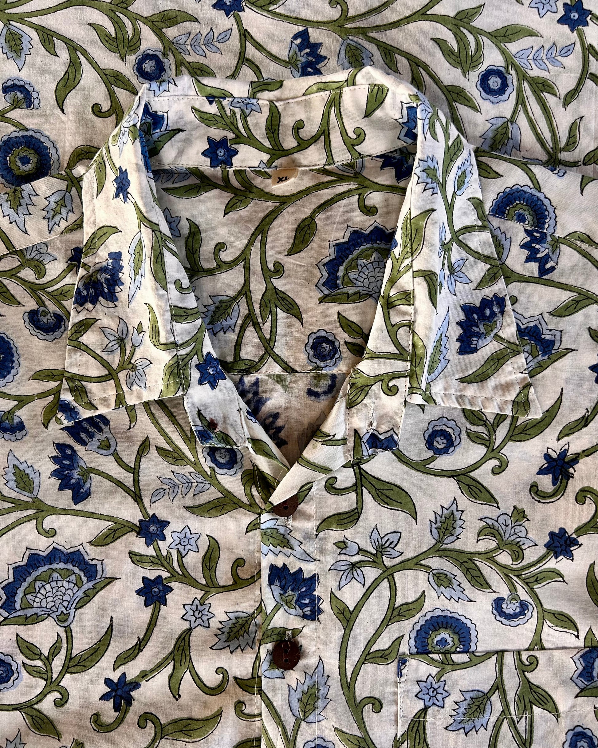 Floral patterned fabric with blue and green flowers on a off white cotton background