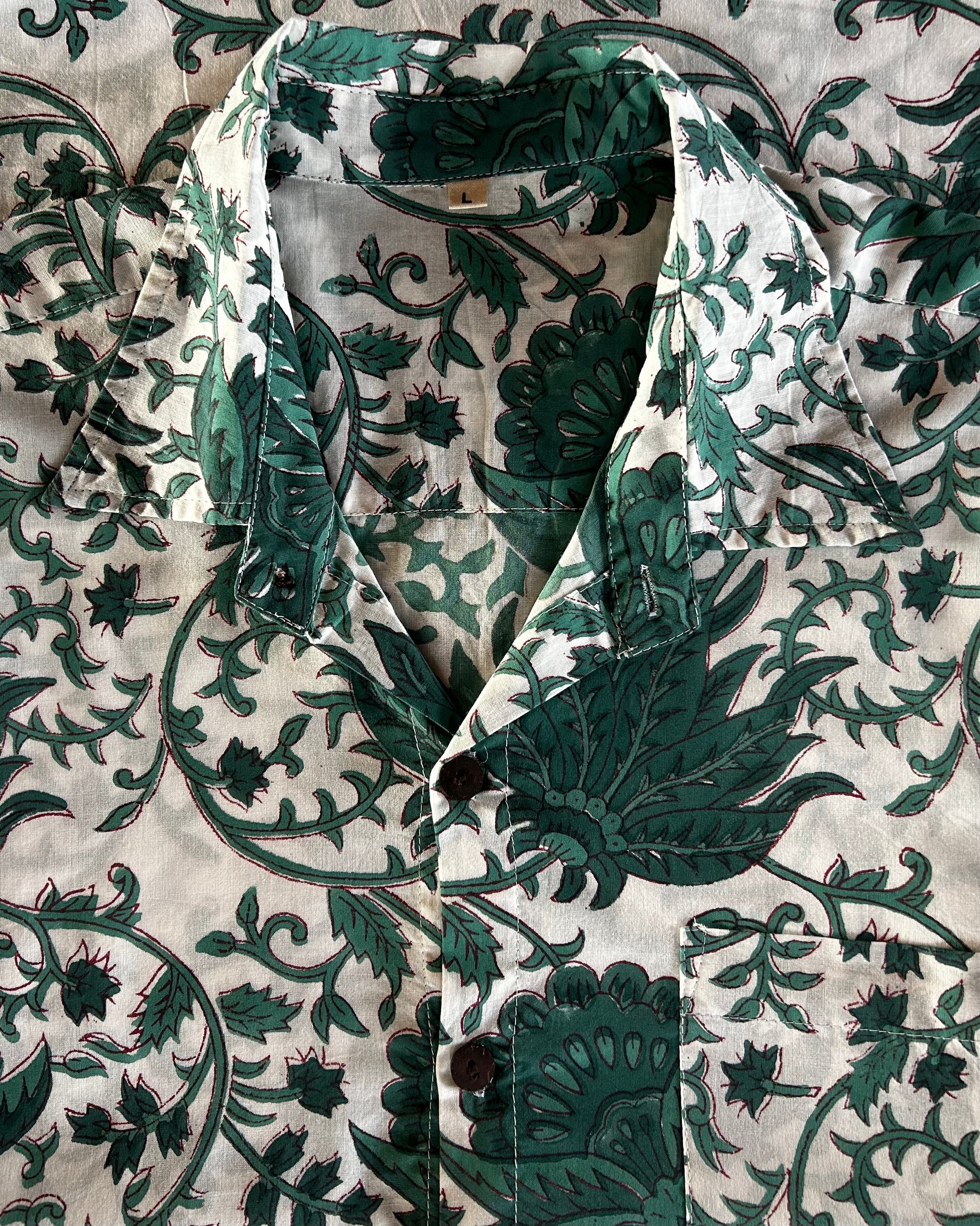 Green and white floral patterned fabric on a textured background