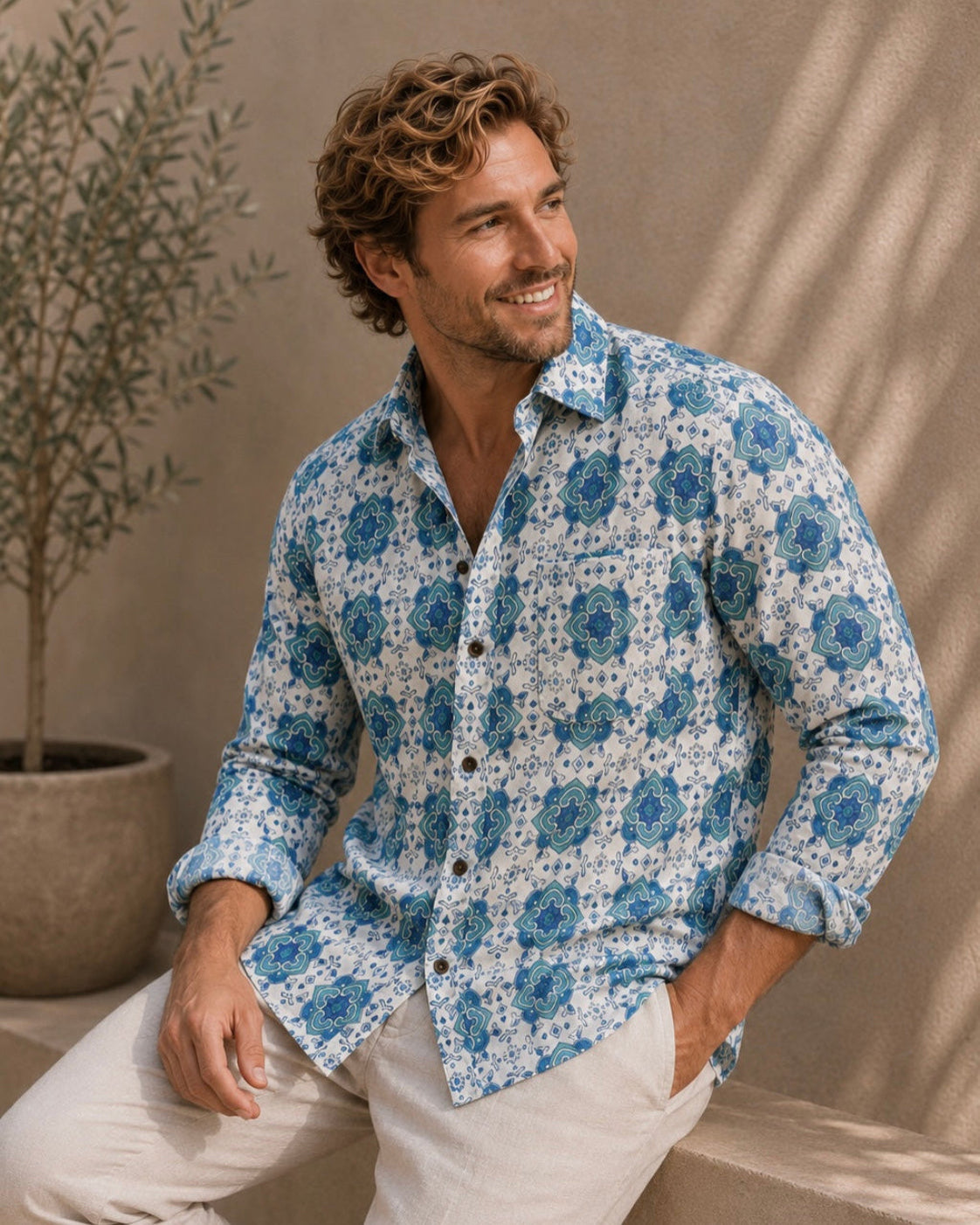 Man wearing a blue floral shirt against a beige wall