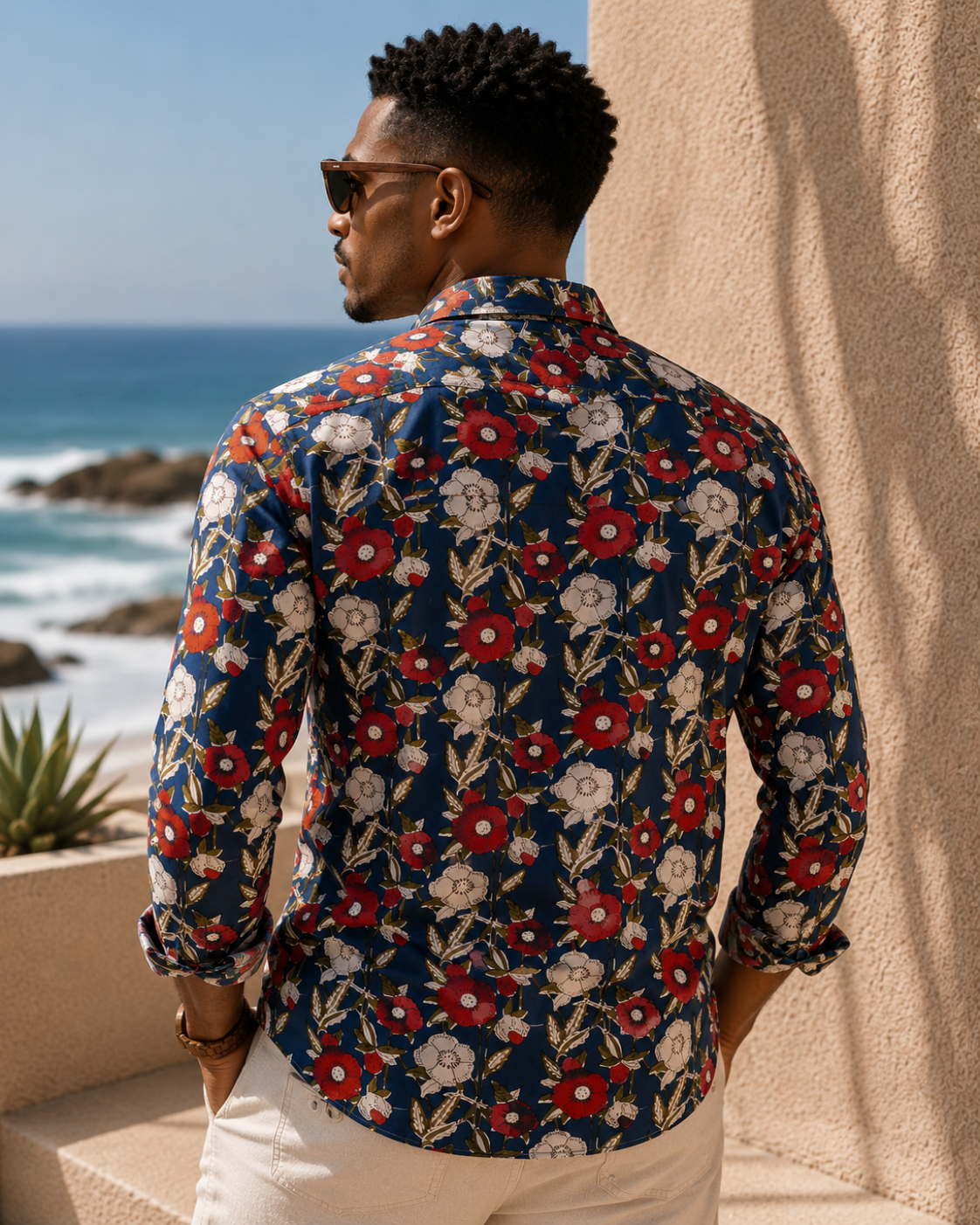 Man wearing a floral shirt by the ocean