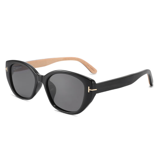Black cat-eye sunglasses with dark gray lenses, gold-tone T-shaped metal accents on the temples, and light natural wood temples.