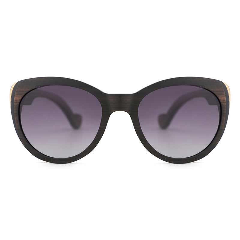 Introducing our newest ladies' sunglasses, The Solange, made from beautiful ebony wood with eye-catching laminate layers visible on the edges.  Handcarved arms with grey polarized lenses to elevate your look.